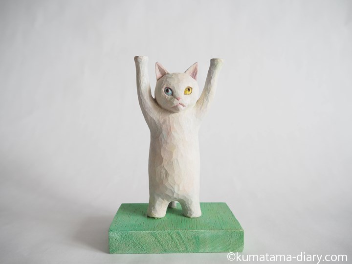 持ち上げる白猫木彫り猫